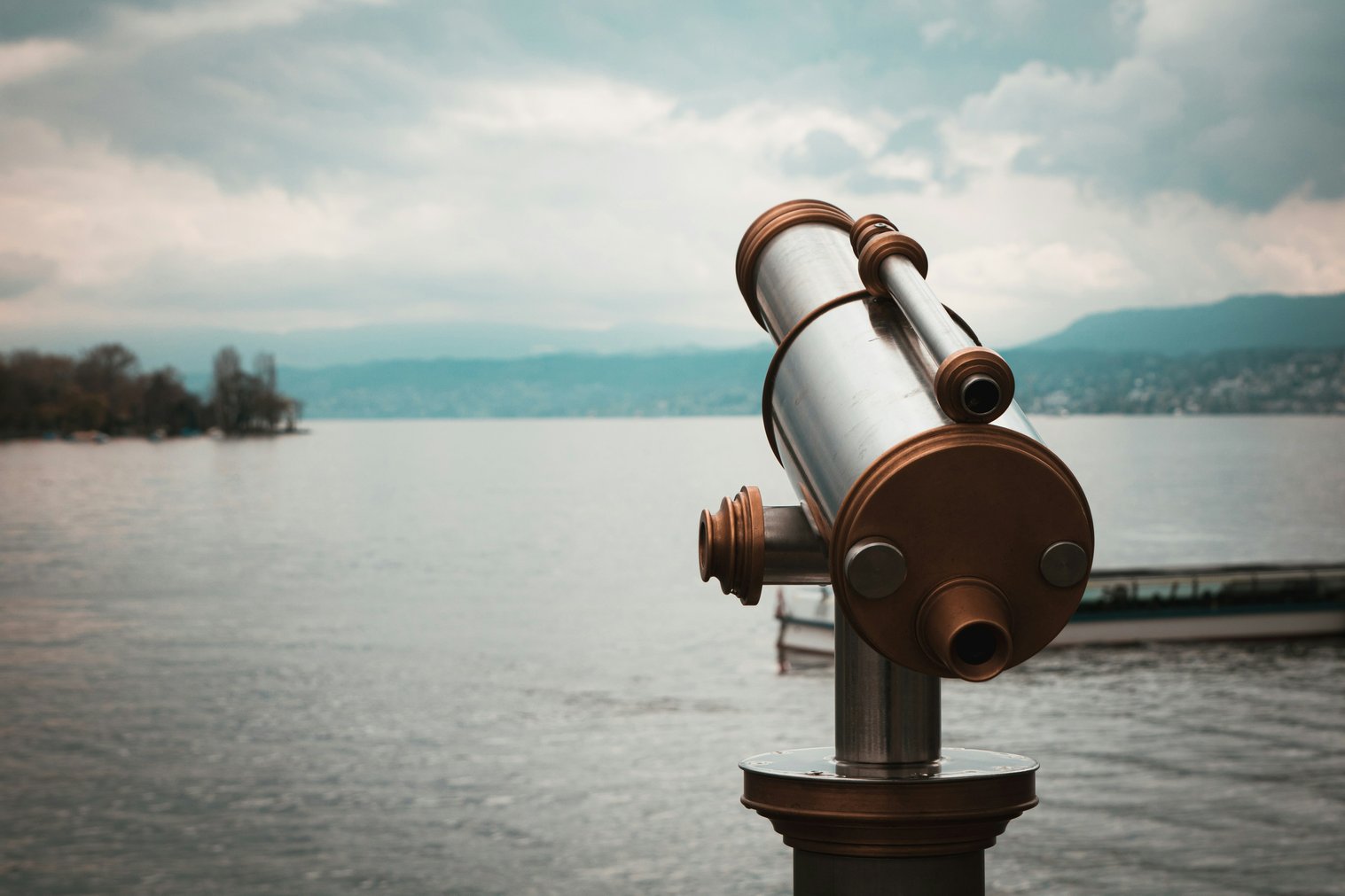 Brown and silver telescope near body of water during daytime