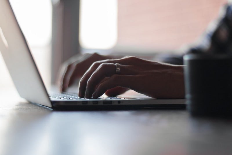 a person touch typing on a laptop