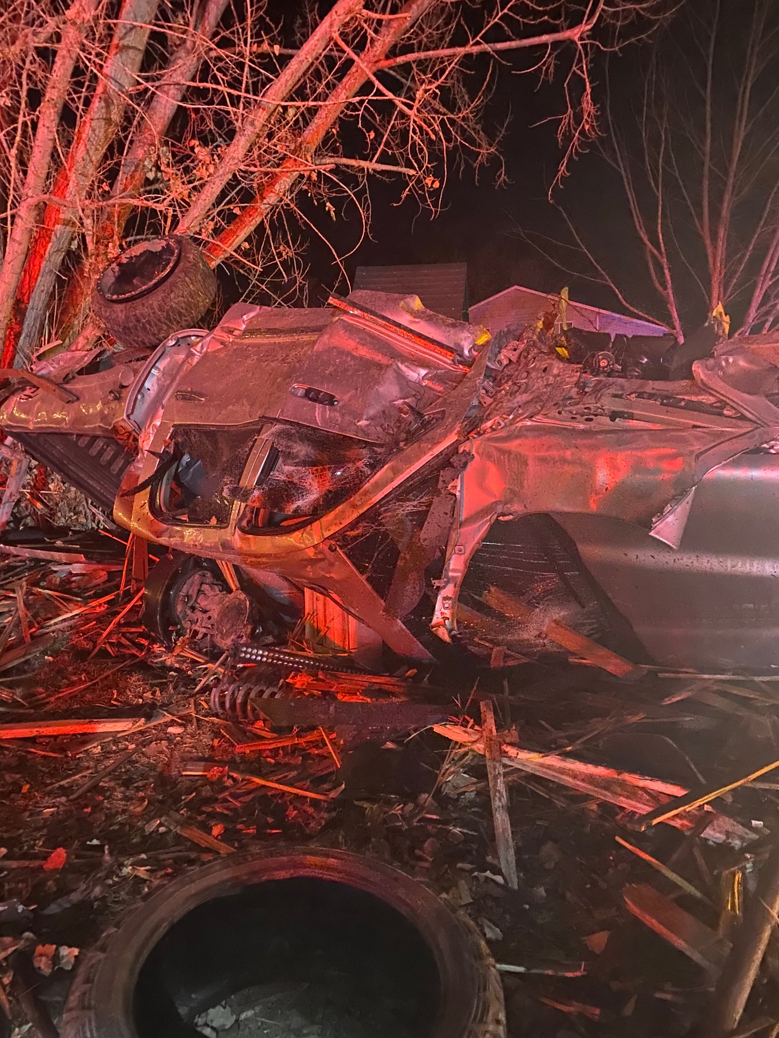 A mangled Dodge Ram 2500 truck up-side-down. It's completely crushed and parts of the truck are strewn about.