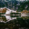 A mountain range with a lake surrounded by snow